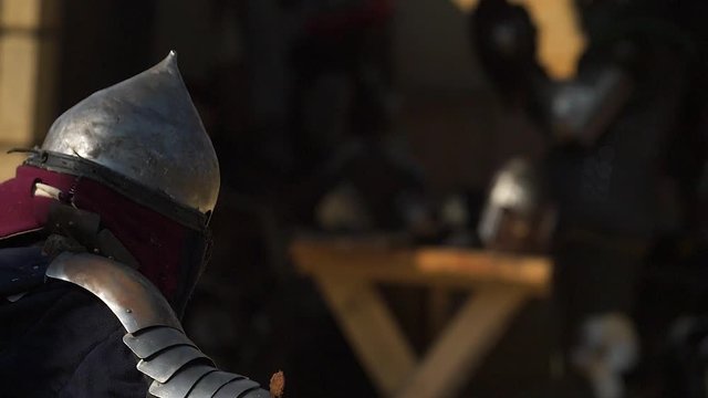 Warrior in a worn armor dodging rival strikes