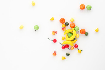 A scattering of many small different fruits on a white background. Mini copy, the concept of diversity of flavors and additives and choice. Multifruit.