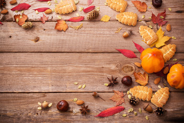 cookies and autumn leaves on  wooden background