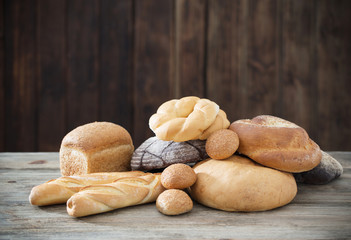 different types of bread on wooden background