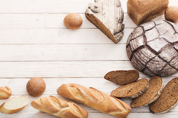 different types of bread on wooden background