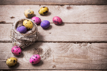 Easter eggs in nest on wooden background