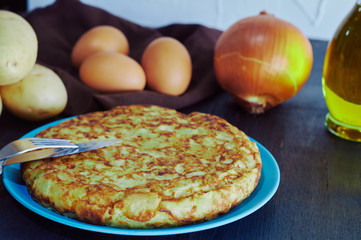 Spanish omelette with potato, egg and onion, accompanied by olive oil