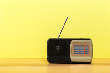 old radio on wooden table with color wall background