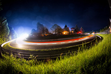 24h Rennen bei Nacht leuchtspuren motorsport atmosphäre hintergrund / long time exposure bulb shot of an 24h car race during night motorsport background