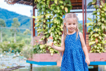 little beautiful girl standing with a bottle of fish food in hand. Yang Bay Vietnam.