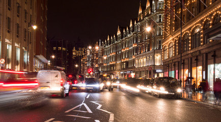 Fototapeta na wymiar London, Uk, january 2019. Night city view, a characteristic detail of the busy city life, taxis, people and wet streets.