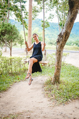Beautiful girl on the swing in the forest