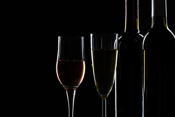  wine bottle and wine glass in a black background
