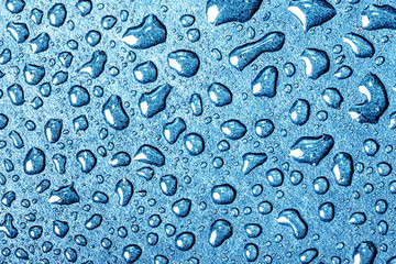 Water drops wet surface background. Blue color rain dew texture.
