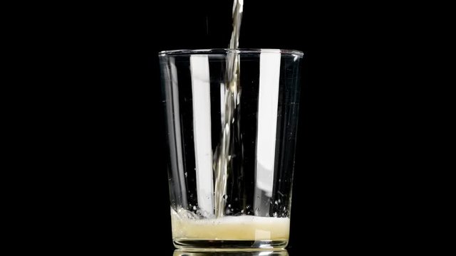 Cerveza cayendo en vaso sobre fondo negro 4k