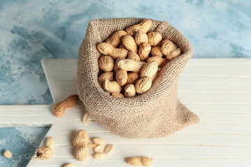 Sack with tasty peanuts on table