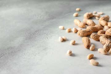 Fototapeta na wymiar Tasty peanuts on grey background