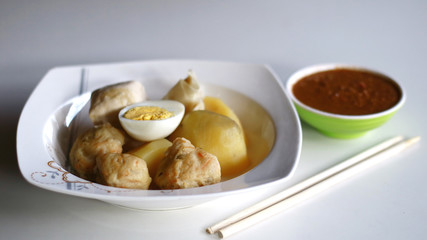 Siomay (fish cake dumplings) and peanut sauce on white background. 