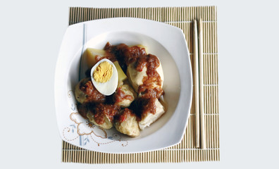 Siomay (fish cake dumplings) and peanut sauce on white background. 