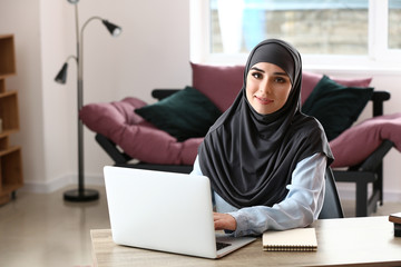 Young Muslim woman working in office