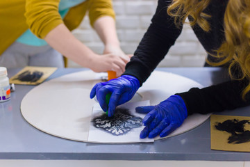 Women hands painting wooden circle