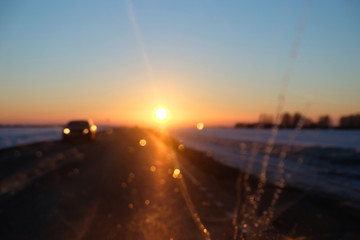 sunset red sun, evening, photo from the car window, traffic on the highway, blurry glare on the glass