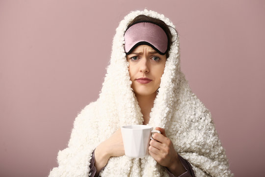 Stressed Woman With Sleep Mask, Cup Of Coffee And Plaid On Color Background