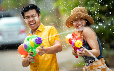 Asian people are using water guns play in the Songkran festival