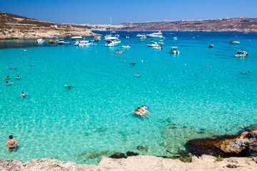 People swiming in blue lagoon at Comino - Malta - obrazy, fototapety, plakaty