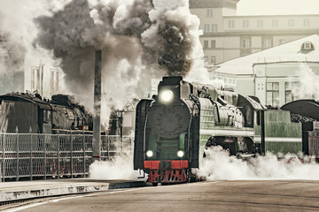 Steam train departs from the railway station.