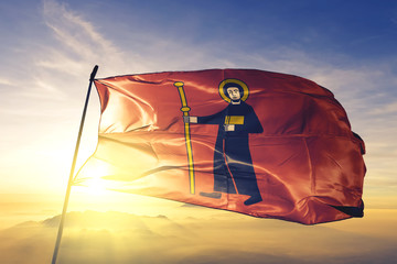 Glarus canton of Switzerland flag waving on the top sunrise mist fog