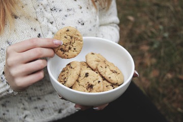 Girl keep a bowl of handmade cookies with chocolate