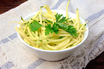 Homemade raw zucchini pasta in ceramic bowl on rustic wooden table. concept of healthy food