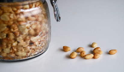 Fried peanuts in a jar on white background.