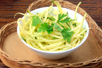 Homemade raw zucchini pasta in ceramic bowl on rustic wooden table. concept of healthy food