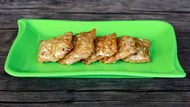 Fried tempeh on wood background. Indonesian traditional food.