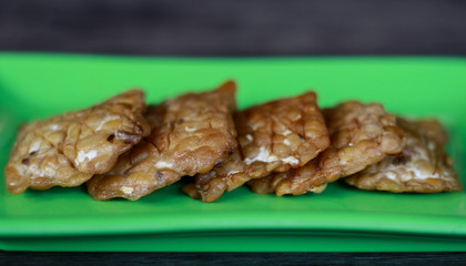Fried tempeh on wood background. Indonesian traditional food.