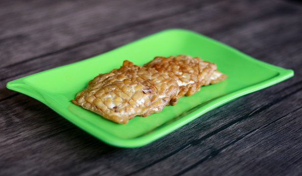 Fried tempeh on wood background. Indonesian traditional food.