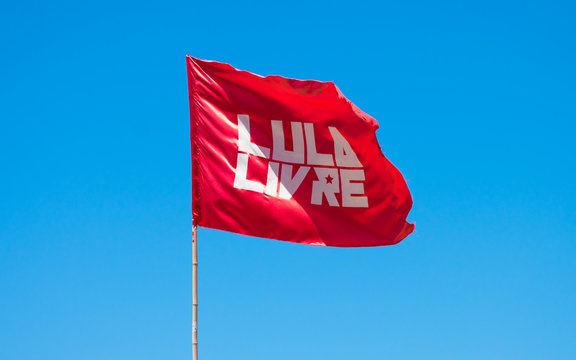 Olinda, Brazil - Circa April 2019: Red flag with "Lula Free" written in Portuguese against blue sky. Lula is an ex-president of Brazil who is currently in jail