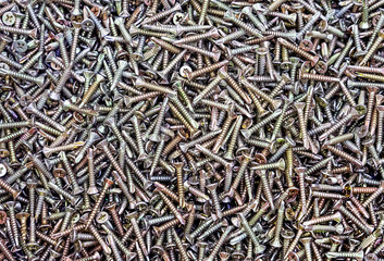Chrome self-tapping screws on the counter of a hardware store. Background of the self-tapping screws.