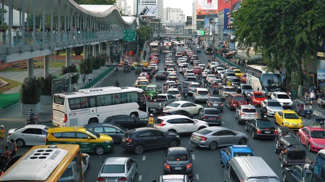 Traffic congestion: cars, motorcycles and buses are moving very slowly on the city avenue