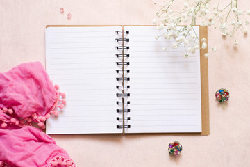Women's diary: an open notebook, a pink scarf, white flowers and multi-colored earrings
