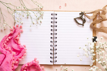 Flat lay: open notepad, white flowers and vintage decoration in the form of a horse (children's swing). Female diary. Maternal diary. Concept: childhood memories or childhood dreams