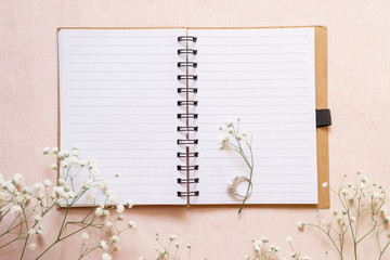 Notebook for planning or romantic diary, white flowers and a ring with pearls. Concept: dreams of a wedding.