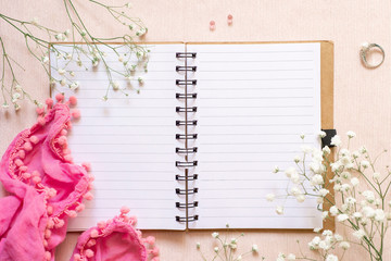 Flat lay: open notebook for records, flowers, a scarf and a wedding ring with pearls. Wedding planning notepad or romantic relationship diary. Concept: dreams of a wedding.