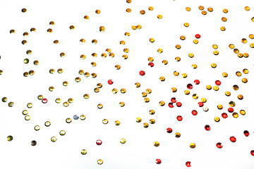 gold sequins scattered on white background