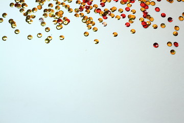 gold sequins scattered on white background