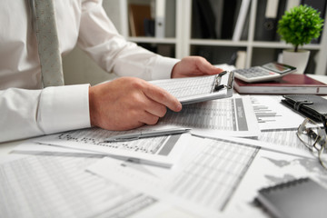 Businessman working at office and calculating finance, reads and writes reports. Business financial accounting concept.