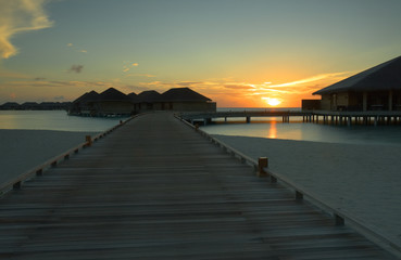 Fototapeta premium Roter Sonnenaufgang am Water Bungalow