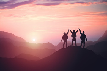 three guys celebrating victory on top of a mountain