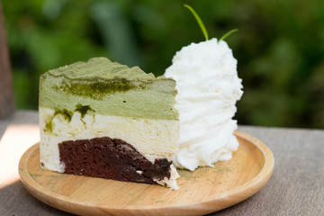 Sweet matcha green tea cake and wipping cream decorated by tea leaves