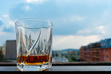 a glass of whiskey against the sky overcast