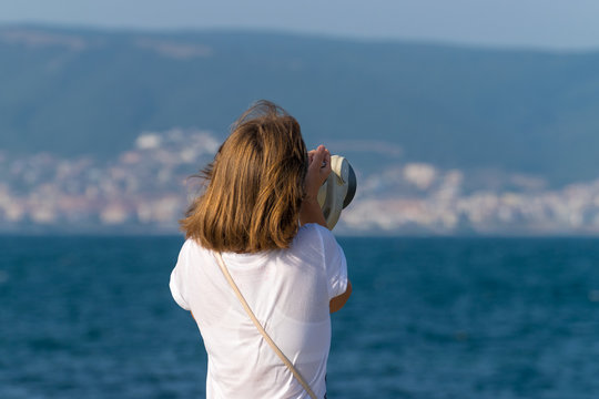 An unidentified girl looking through a tower viewer at sea in Nessebar, Bulgaria. A girl looking through a coin binocular, free use viewer, outdoor viewer