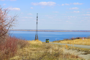 Obraz premium THE BUS GOES ON THE BACKGROUND OF THE RIVER